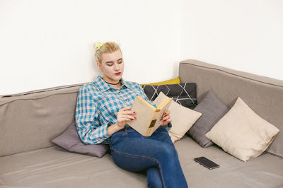 Young woman sitting on sofa at home