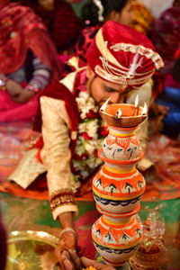 Bridegroom sitting by diya during wedding ceremony