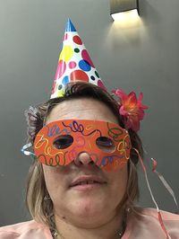 Close-up portrait of woman wearing eye mask and party hat