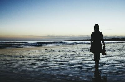 Silhouette of woman standing on beach