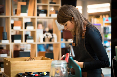 Young female saleswoman in handicraft store