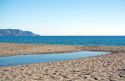 Scenic view of sea against clear blue sky