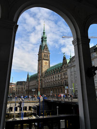 Town hall seen through arch against sky