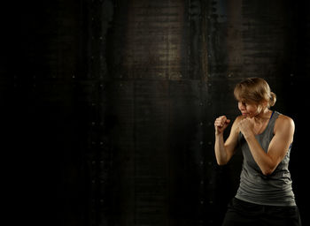 Athlete standing in fighting stance against wall