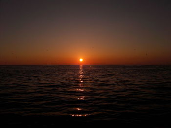 Scenic view of sea against orange sky