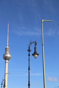 Low angle view of street light against blue sky