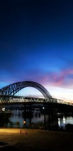 Illuminated bridge against sky at night