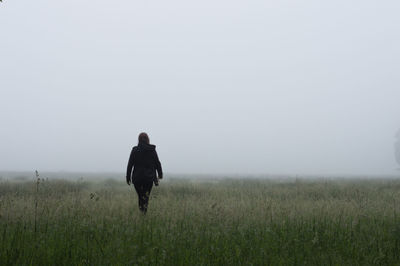 Man standing on field in foggy weather