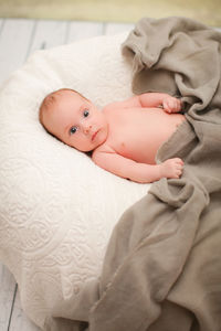 Portrait of cute baby lying on bed