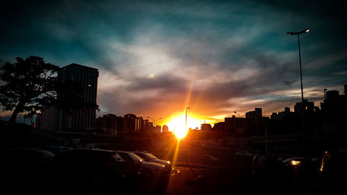 Silhouette city against sky during sunset