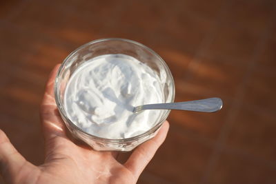 Midsection of person holding ice cream in glass