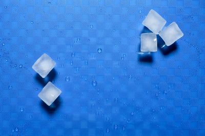 High angle view of dices on blue background