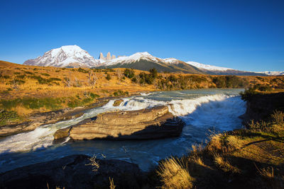 Scenic view of snowcapped mountains against blue sky