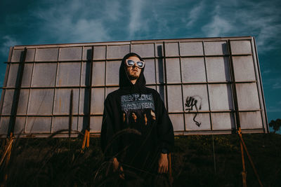 Portrait of man standing against wall