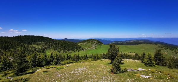 Scenic view of mountains against blue sky