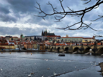 River by buildings in city against sky