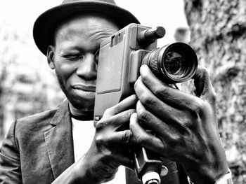 Close-up of man photographing through camera