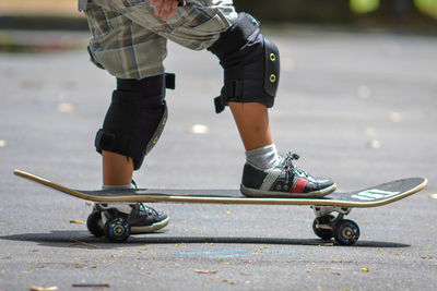 Low section of man skateboarding on street