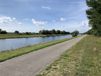 Road by lake against sky