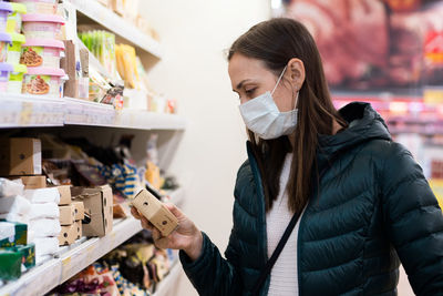 Portrait of young woman looking at store