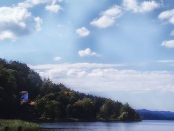 Scenic view of calm lake against cloudy sky