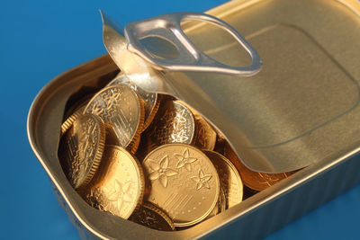 Close-up of coins in container against blue background