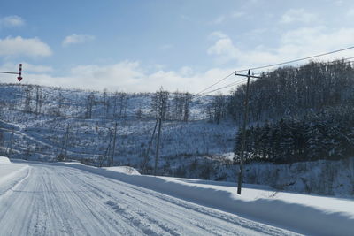 Snow covered land and trees against sky