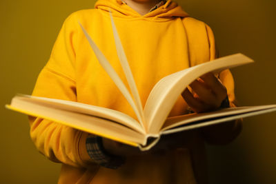 Midsection of woman reading book