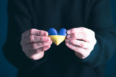 Midsection of woman holding heart shape