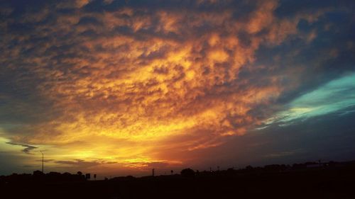 Silhouette of landscape against cloudy sky