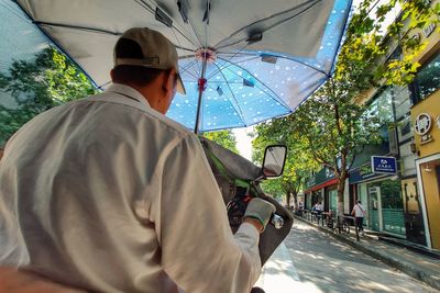 Rear view of man on street during rainy season