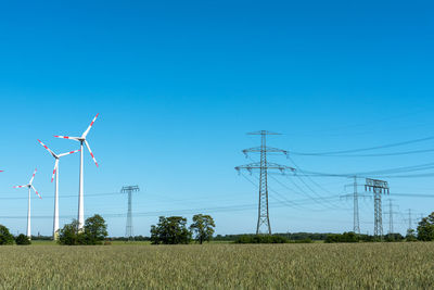 Overhead lines and wind turbines on a sunny day seen in germany