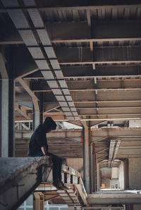 Side view of man standing on staircase in building