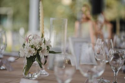 Flower vase on table against glass wall