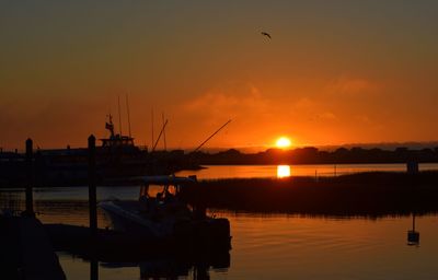 Silhouette sailboats in sea against sky during sunset