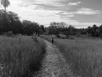 Man on road amidst trees against sky