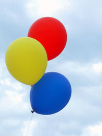 Low angle view of balloons against sky