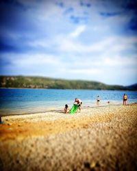 People at beach against sky