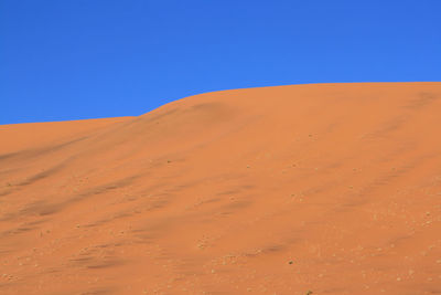 View of desert against clear blue sky