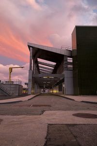 View of street amidst buildings against sky during sunset