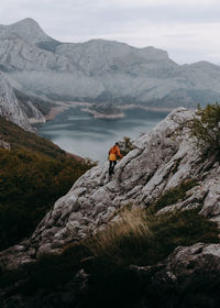 Man on rock by mountains