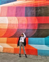 Full length of man standing against wall