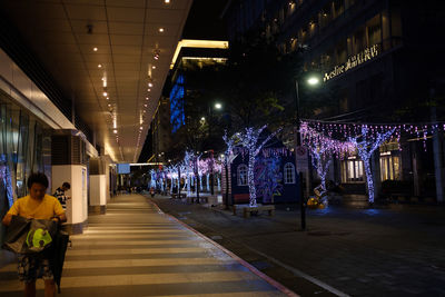 People walking in illuminated city at night