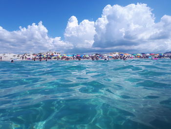 People on sea shore against sky
