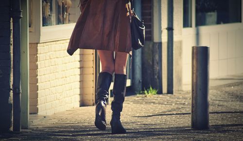 Low section of woman walking on street