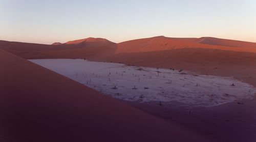 Scenic view of snowcapped mountains against clear sky during sunset