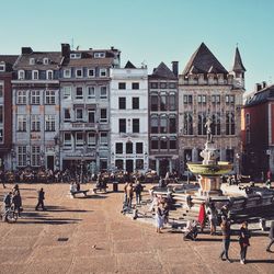 People on street against buildings in city