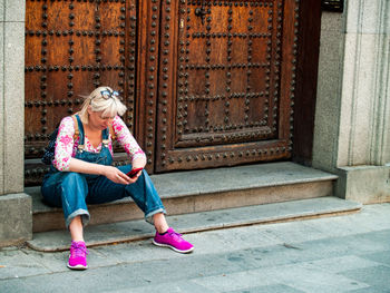 Full length of woman sitting outdoors