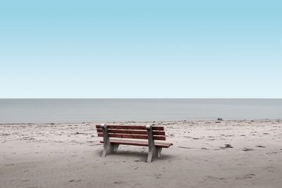 A empty bench early one sunny morning at sauble beach, ontario.