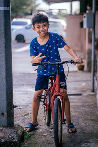 Portrait of boy riding bicycle on street